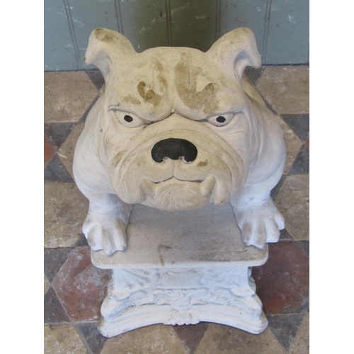 1107 - A cast composition stone garden ornament in the form of a seated bulldog raised on associated pedest... 