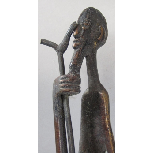 678 - African bronze sculpture of an elongated figure of a man holding a walking stick raised on a stepped... 