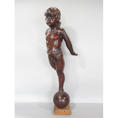 681 - A carved mahogany cherubic figure balancing on a sphere, ( The right leg is present to be reattached... 