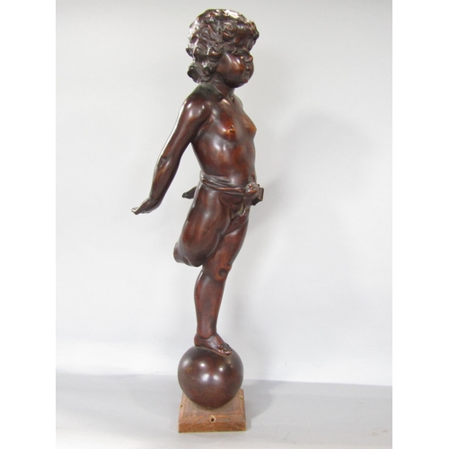 681 - A carved mahogany cherubic figure balancing on a sphere, ( The right leg is present to be reattached... 