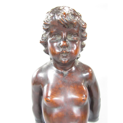 681 - A carved mahogany cherubic figure balancing on a sphere, ( The right leg is present to be reattached... 