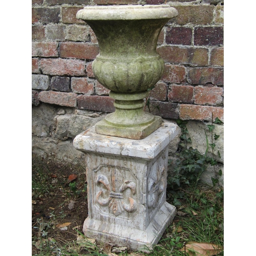 1040 - A small weathered marble urn with flared rim, 30 cm in diameter x 38 cm high, raised on an associate... 