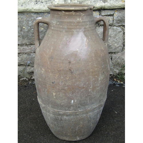 1072 - An old buff coloured terracotta jar with moulded loop handles 55 cm high