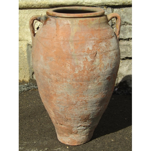 1078 - An old weathered terracotta oviform jar with moulded loop handles, moulded rim and glazed collar, 52... 