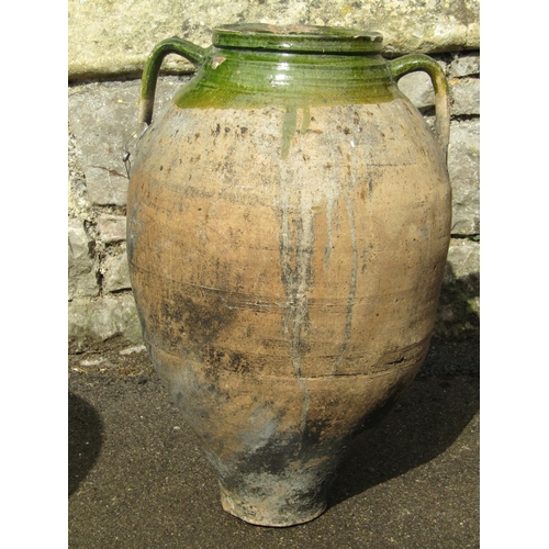 1079 - An old oviform jar with green glazed neck and open moulded loop handles, 57 cm high