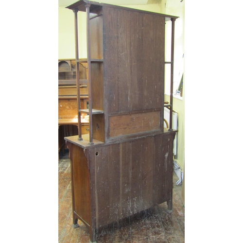 1613 - An arts and crafts oak dresser, the lower section enclosed by a pair of panelled doors, partially gl... 