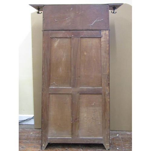 1615 - An arts and crafts oak hall robe of tapering form enclosed by a central door with quarter panelled g... 