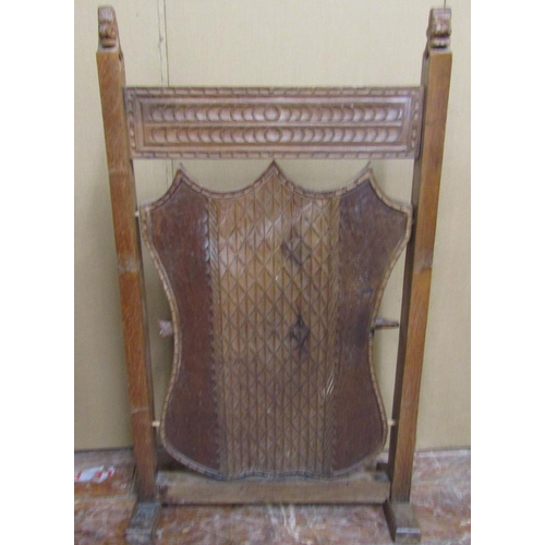 1623 - A late 19th century oak firescreen, the side shield shaped central panel with geometric detail, supp... 