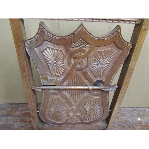 1623 - A late 19th century oak firescreen, the side shield shaped central panel with geometric detail, supp... 