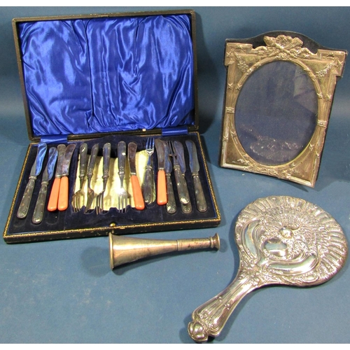 195 - A silver peacock embossed hand mirror, a silver photo frame, silver handled fruit knives and forks a... 