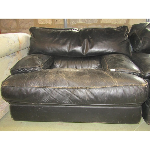 1378 - A pair of low substantial easy chairs with soft black leather upholstered finish and loose shaped fe... 