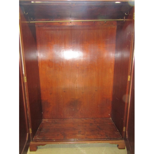 1393 - An Edwardian mahogany hanging wardrobe in a Georgian style enclosed by two panelled doors, 130cm