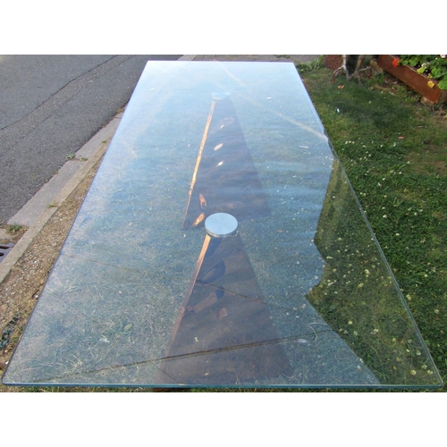 1418 - A contemporary dining table with toughened plate glass top, raised on a pair of copper prism taperin... 