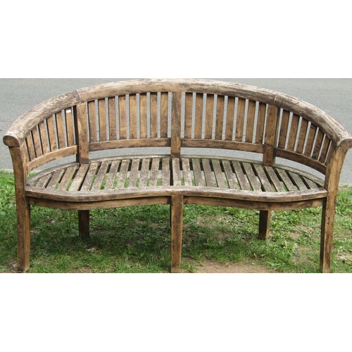 1059 - A stained hardwood banana shaped garden bench 160 cm wide