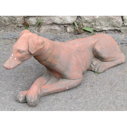 1113 - A cast composition stone garden ornament in the form of a recumbent greyhound/whippet with terracott... 