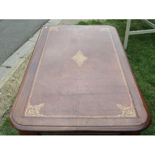 1193 - A mahogany writing table, the rectangular top with moulded outline, rounded corners and inset leathe... 