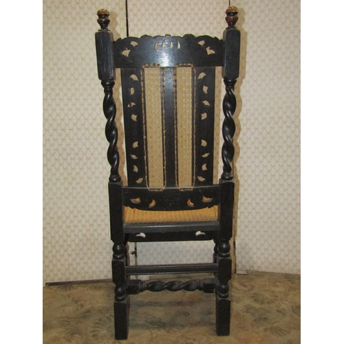 1205 - A single antique oak chair in the Carolean style with cane panelled seat and back beneath a carved c... 