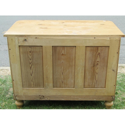 1214 - A stripped pine bedroom chest of two long and two short drawers with bar handles, flanked by rounded... 