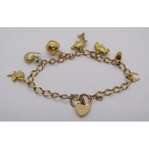 231 - 9ct curb link charm bracelet with heart padlock clasp, hung with seven novelty charms to include an ... 