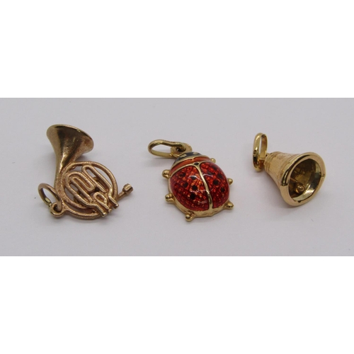 304 - Three 9ct charms comprising an enamelled ladybird, a French horn and a bell, 3.6g total