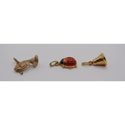 304 - Three 9ct charms comprising an enamelled ladybird, a French horn and a bell, 3.6g total