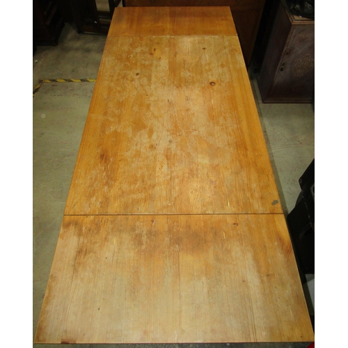 1233 - A stripped pine drop-leaf kitchen dining table with rectangular top raised on square cut and slightl... 