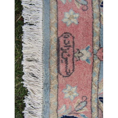 1792 - A mid 20th century Persian Qum rug with a signature with pink flowers on a pale blue ground, 150cm x... 