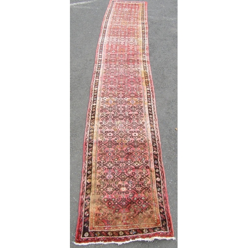 1812 - A Hamadan runner with a repeating geometric pattern on a predominantly pink ground, 500cm x 88cm.