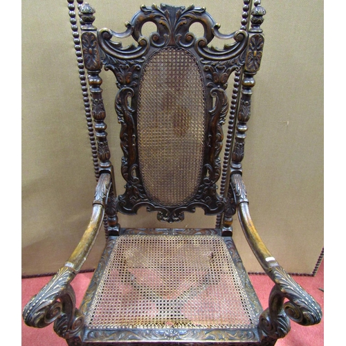 1522 - A Carolean style elbow chair in walnut, the well carved frame supporting a cane panelled seat and ba... 