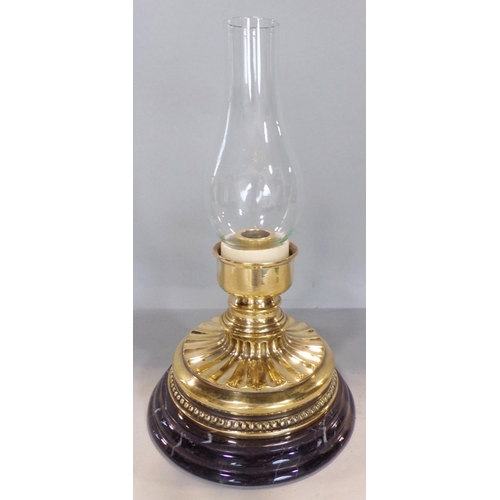 693 - A squat Victorian brass candlestick with a flared wavy stand raised on a marble base, with an adapte... 