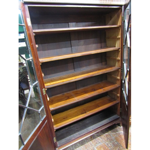 1549 - A Georgian mahogany bookcase enclosed by a pair of panelled doors with partial astragal glazing, rai... 