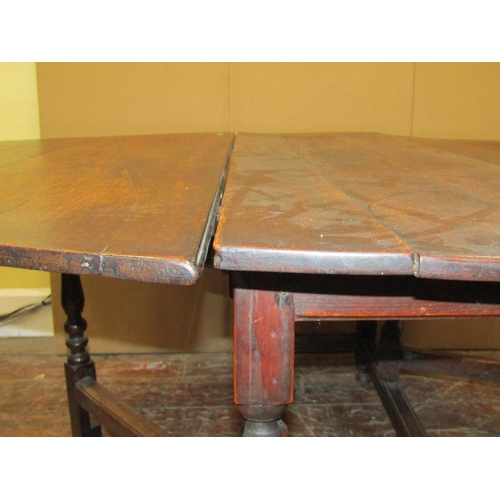 1552 - A Georgian oak gateleg table on turned supports, 130cm long to seat six