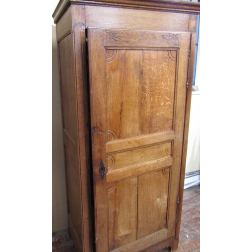 1564 - An early 19th century oak livery cupboard enclosed by a panelled door, within a pegged frame with br... 