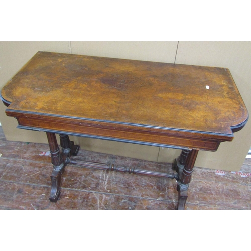 1572 - A Victorian walnut and burr walnut foldover top card table, raised on a stretcher base, supported by... 