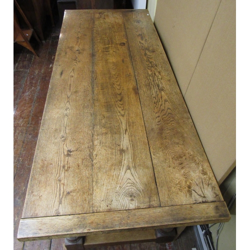 1585 - A traditional oak refectory table, the heavy planked top with cleated ends, raised on four turned su... 