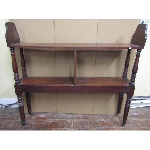 1604 - An unusual 19th century mahogany and pine two tier bookcase or stand, with two tiers on turned suppo... 