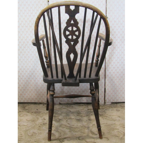 1352 - A Windsor stained elm and beechwood hoop and stick back open elbow chair with central pierced wheel ... 