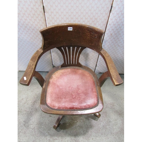 1345 - An early 20th century oak swivel office desk chair with comb splat over upholstered leather pad seat... 