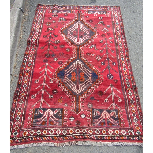 1784 - A Persian rug with stylised birds and flowers and an interlocking medallion on a red ground, 164cm x... 