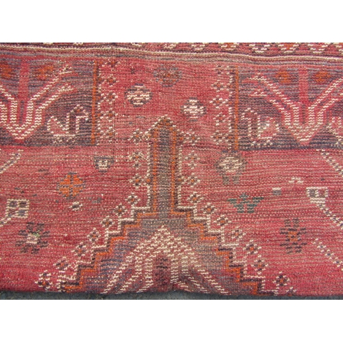 1784 - A Persian rug with stylised birds and flowers and an interlocking medallion on a red ground, 164cm x... 