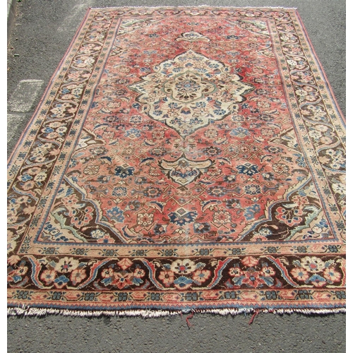 1785 - A Persian Kashan carpet with with a central medallion with an all over floral pattern on a faded red... 