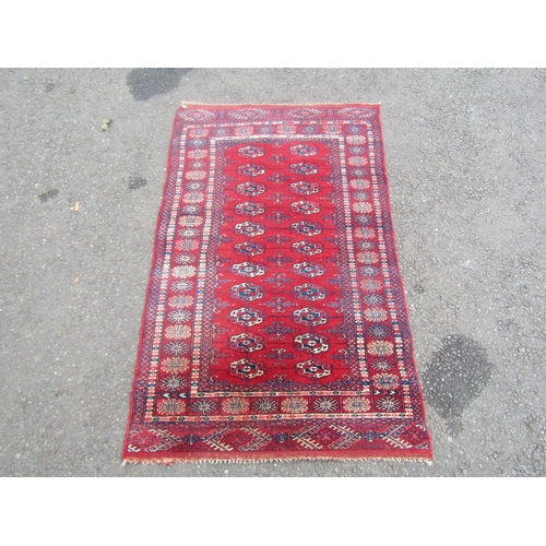 1796 - A Bokhara rug with two row of elephant foot medallions on a predominantly red ground, 130cm x 80cm a... 