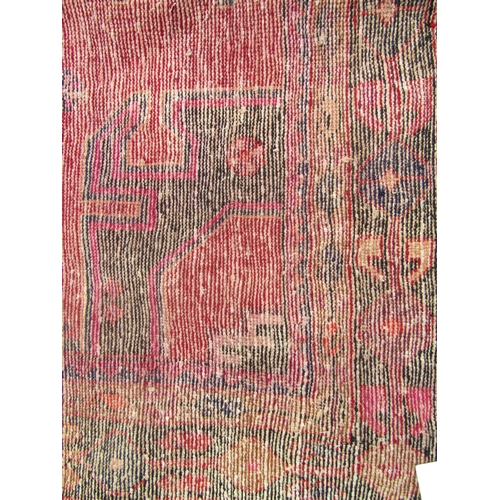 1804 - North east Persian Kurdie rug  with an extended hooked medallion and a geometric border on a red gro... 