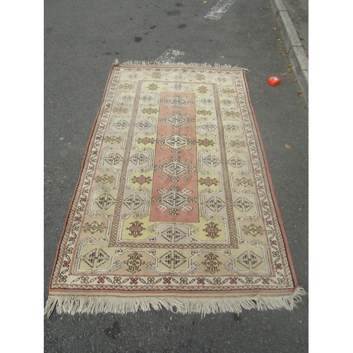 1819 - A Kazak corridor rug with several rows of medallions in faded tones of brown and yellow, 210cm x 120... 