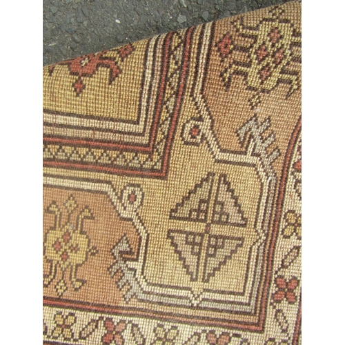 1819 - A Kazak corridor rug with several rows of medallions in faded tones of brown and yellow, 210cm x 120... 