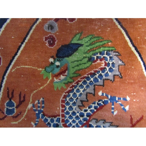 1822 - An oval Tibetan rug with a blue dragon with a green head on an apricot ground 145cm x 78cm approx