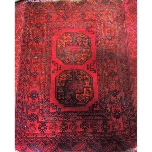 1823 - A small Turkoman rug with two elephant foot on a red ground 120cm x 80cm approx.