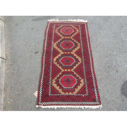 1795 - A Turkoman type carpet with four repeating diamond shaped medallions , 164cm x 83cm approx