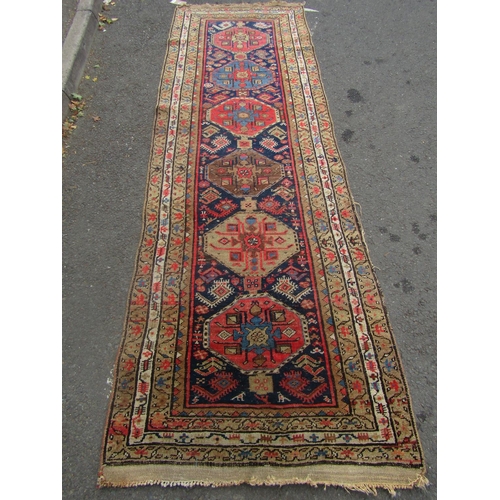 1801 - An Kazak design runner with a row of six gul to the centre 300cm x 95cm approx