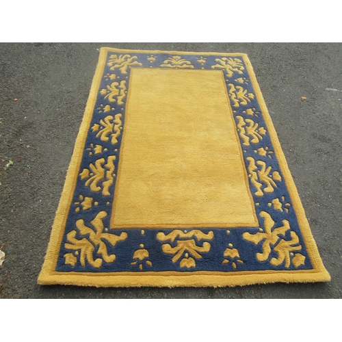 1813 - A thick pile wool carpet with a yellow rectangular panel and a yellow and blue border, 180cm c 120cm... 